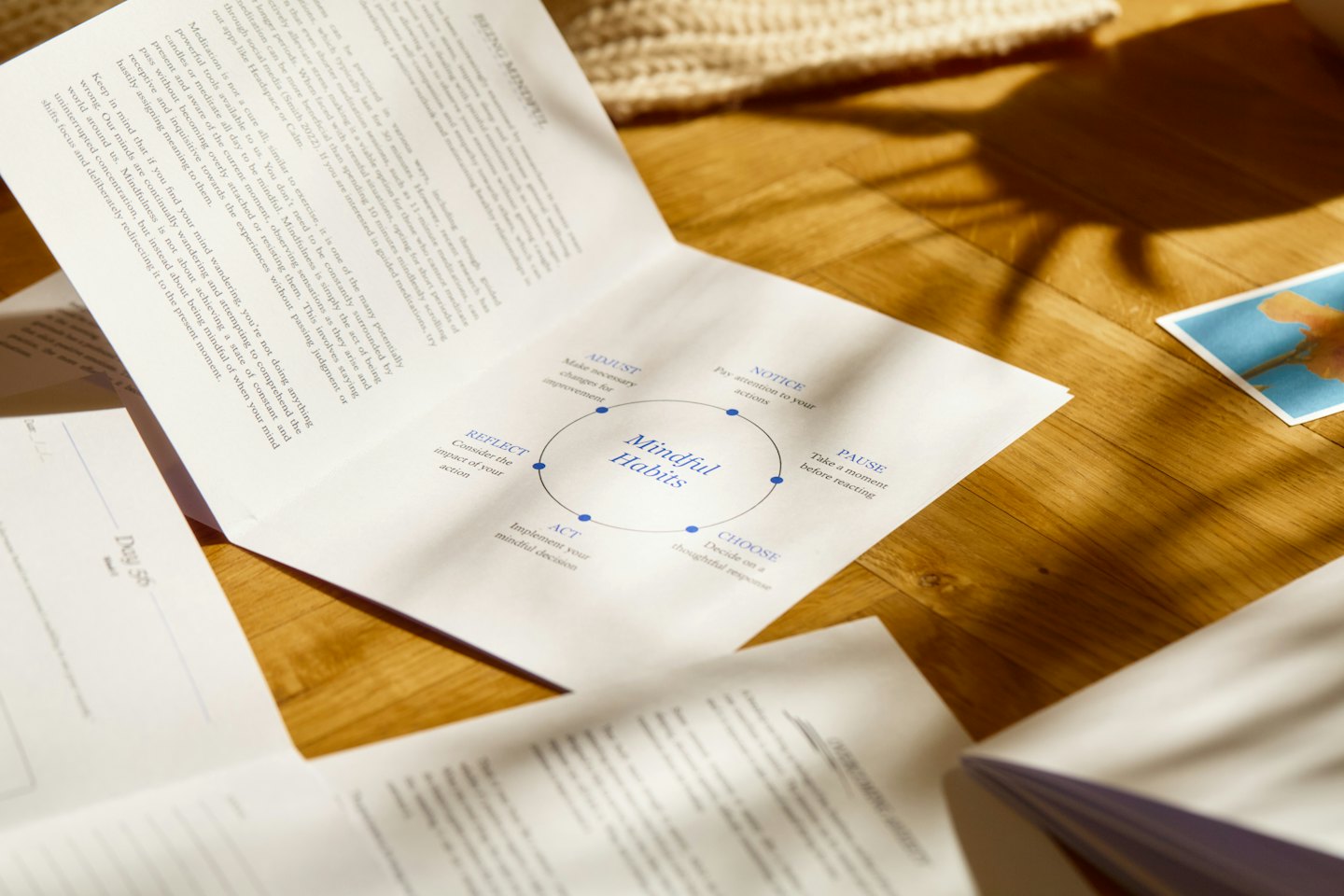 Open journals and a diagram on a wooden floor.