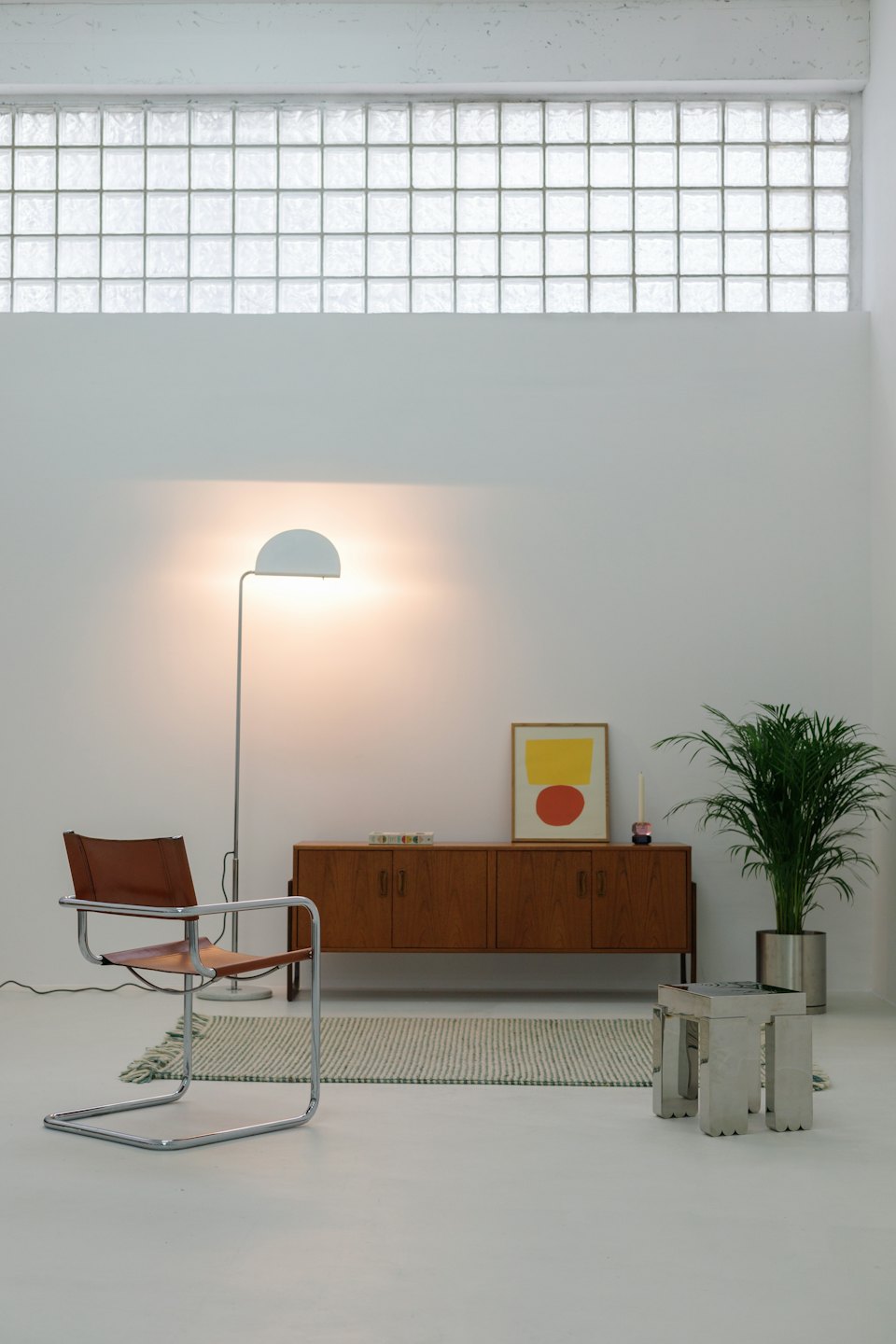 Modern minimalist room with a leather chair and houseplant.
