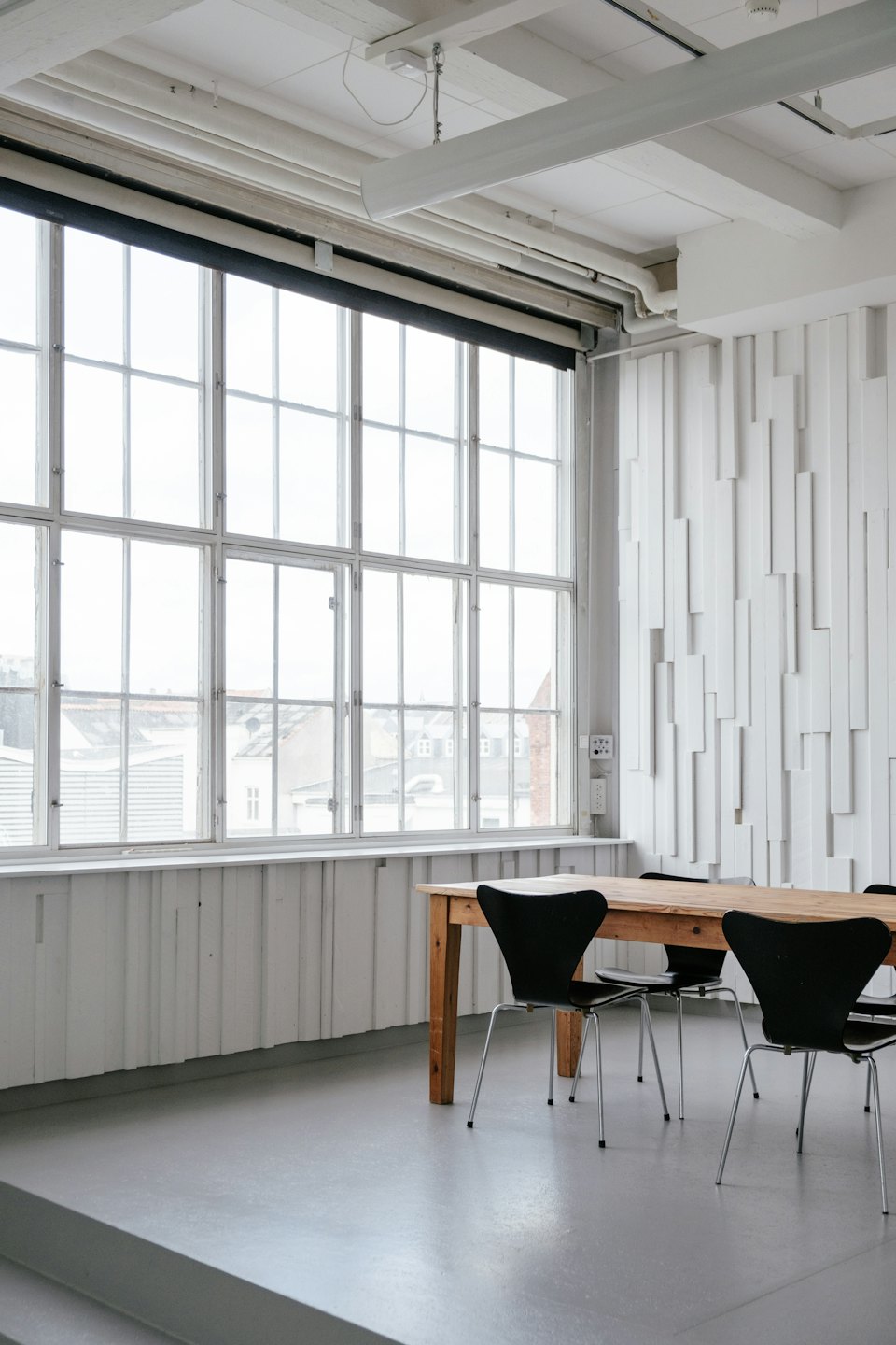 Modern meeting room with a long wooden table and chairs.