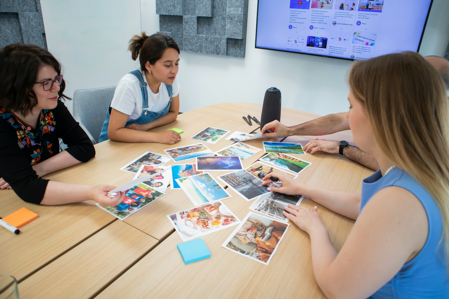Three professionals brainstorming with photos around a table.